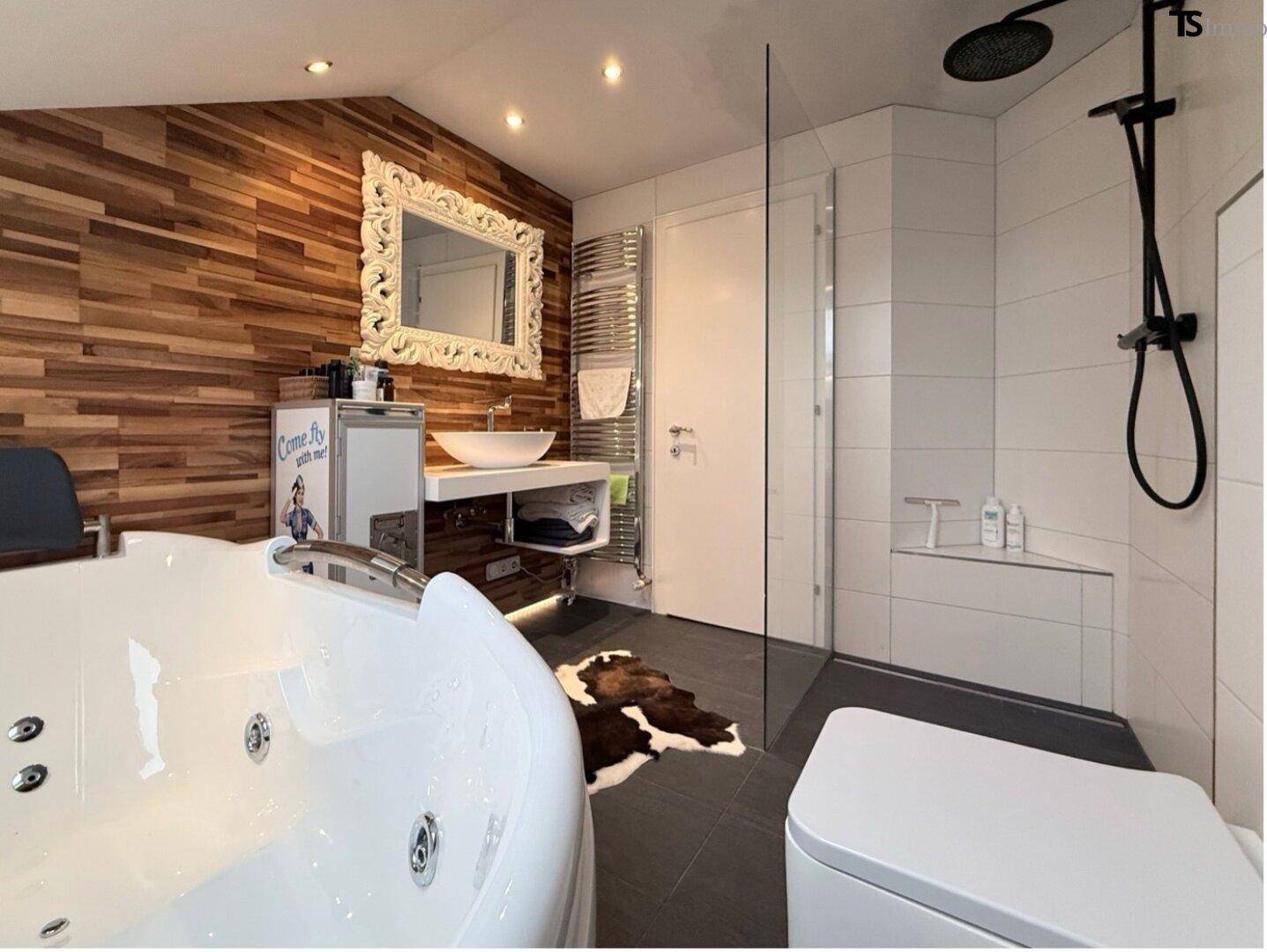 Elegantes Badezimmer mit Whirlpool, begehbarer Dusche und modernem Waschtisch.
