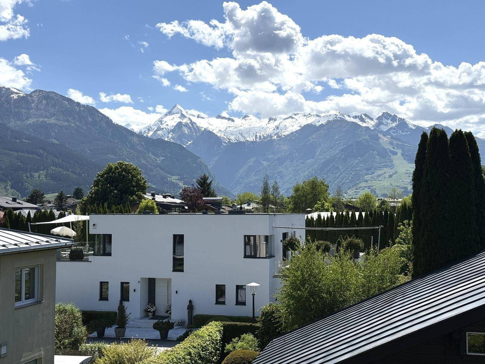 Moderne weiße Villa mit Flachdach und beeindruckendem Blick auf die schneebedeckten Berge.