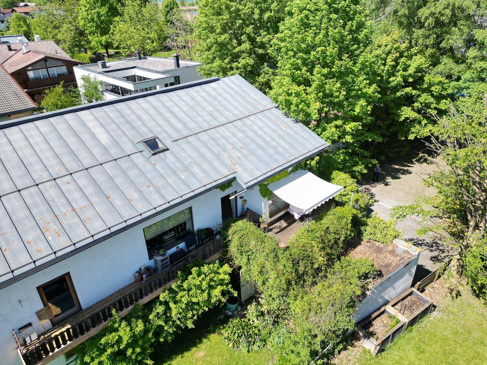 Vogelperspektive eines Hauses mit Satteldach, Balkon und Gartenbereich.