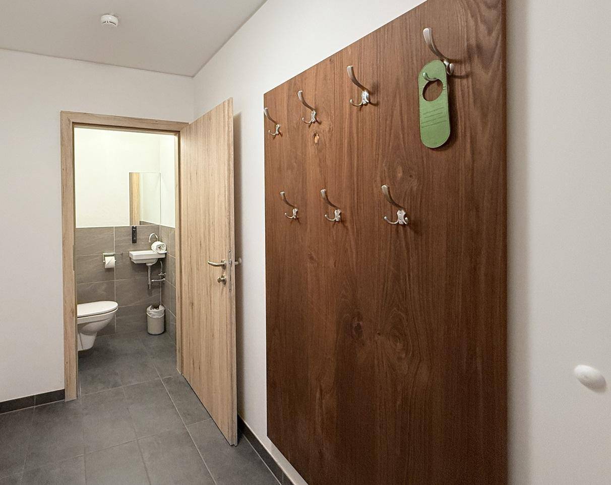 Heller Flur mit praktischer Garderobe und Zugang zu einem separaten Gäste-WC.