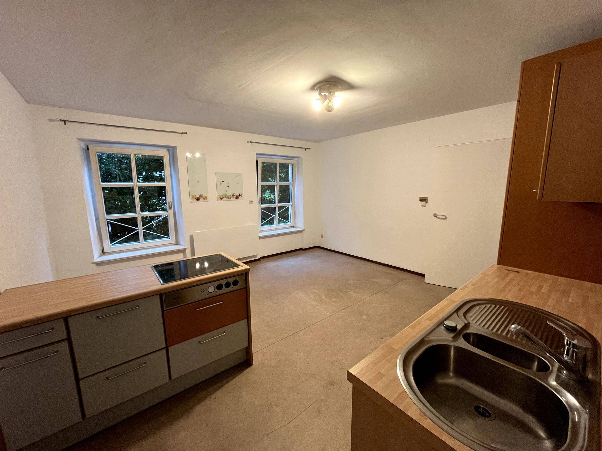 Funktionale Küche mit Spüle, Kochfeld und Holz-Arbeitsplatten, bereit zur Ergänzung.