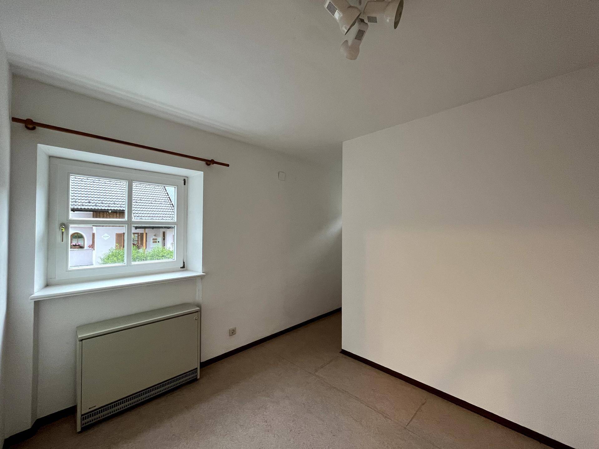Gemütliches Zimmer mit einem Fenster und Heizkörper, ideal als Schlaf- oder Arbeitszimmer.