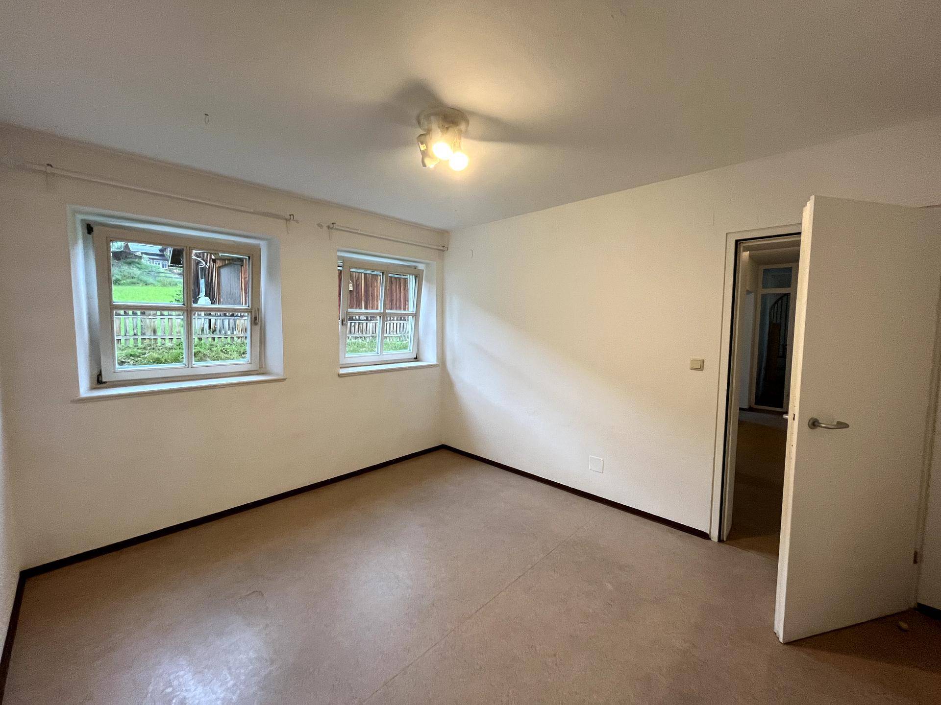 Geräumiges Schlafzimmer mit zwei Fenstern, die viel Licht und eine ruhige Atmosphäre schaffen.