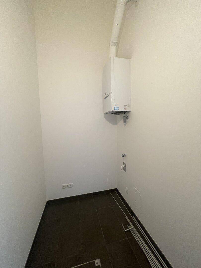 Praktischer Hauswirtschaftsraum mit Gastherme und Anschlüssen für Waschmaschine.