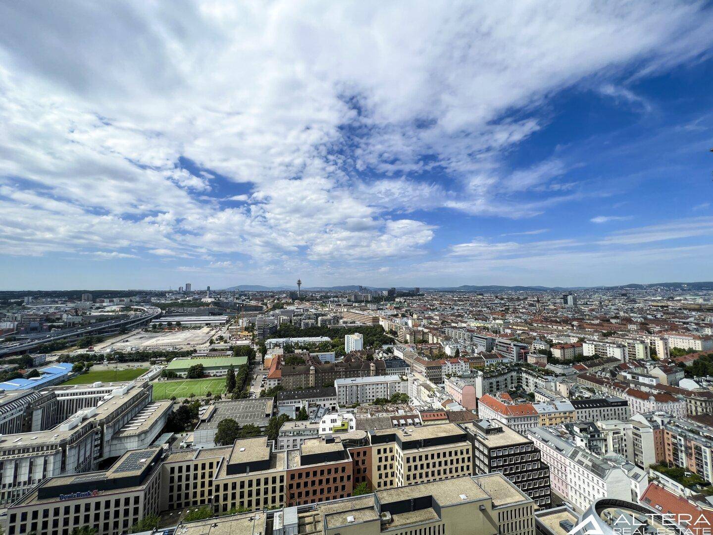 Weitläufiger Panoramablick über die Stadtlandschaft unter einem bewölkten Himmel.