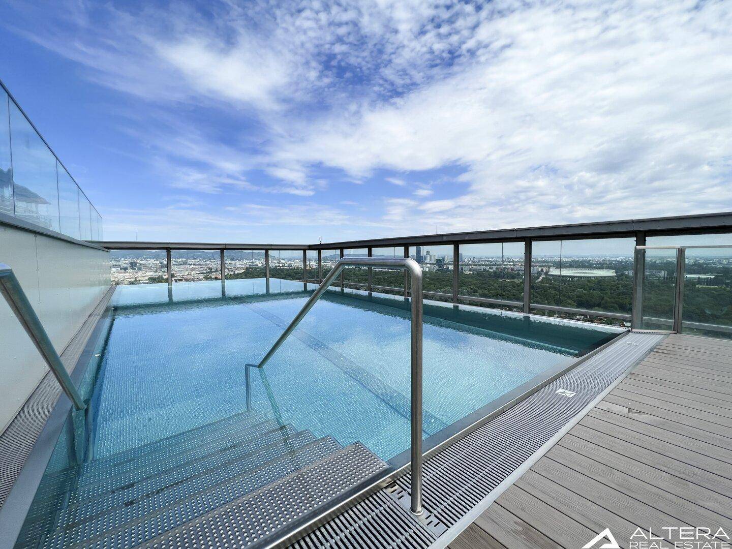 Exklusiver Dachpool mit Glasgeländer und atemberaubendem Blick über die Stadt.