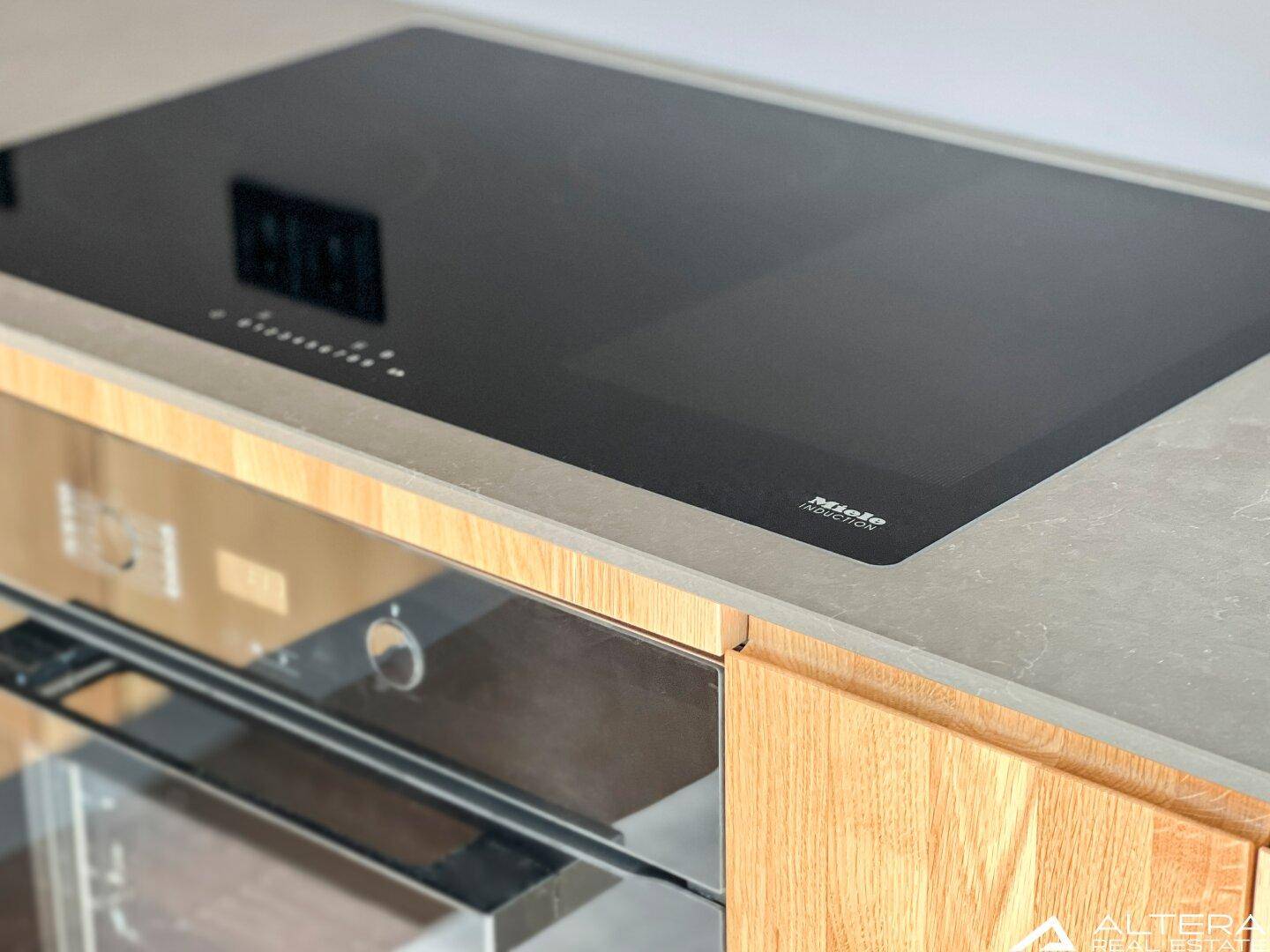 Hochwertiges Miele Induktionskochfeld und Backofen in moderner Einbauküche.
