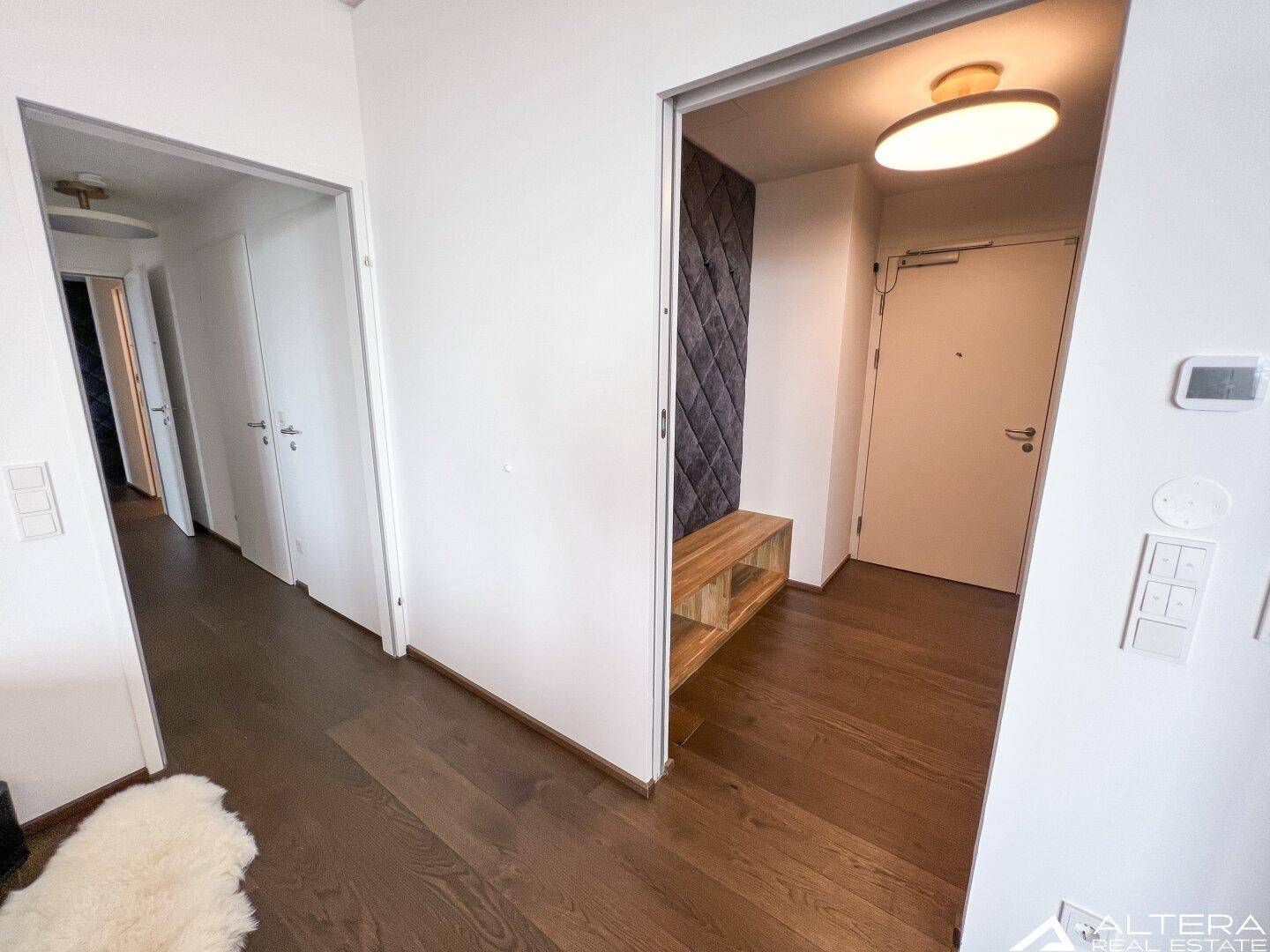 Heller Flur mit Holzboden und modernem Designelement an der Wand.