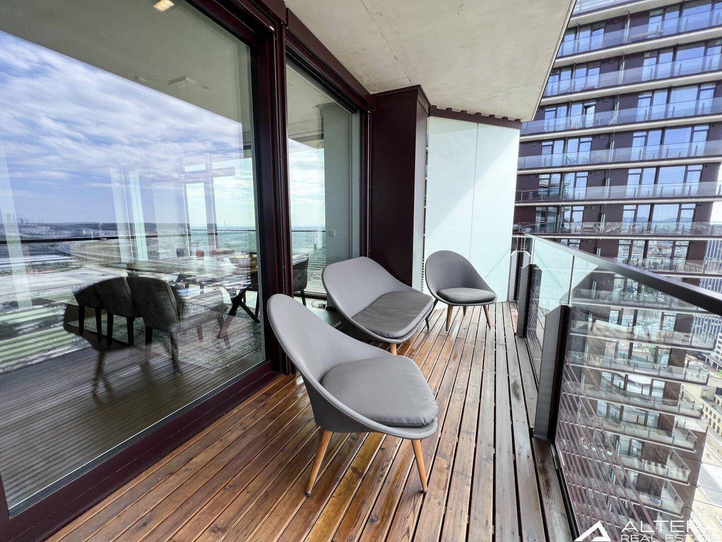 Balkon mit modernen Sitzgelegenheiten und Blick auf die umliegenden Gebäude.