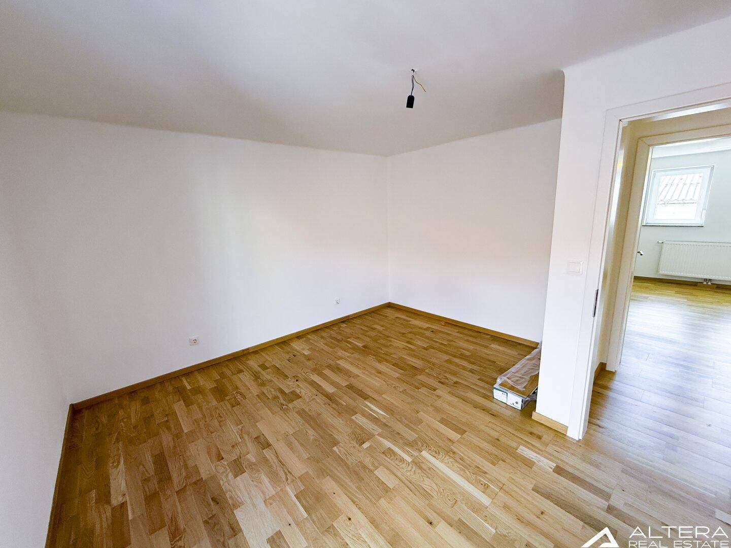 Geräumiges Schlafzimmer mit Parkettboden und weiß gestrichenen Wänden, bereit zur individuellen Gestaltung.