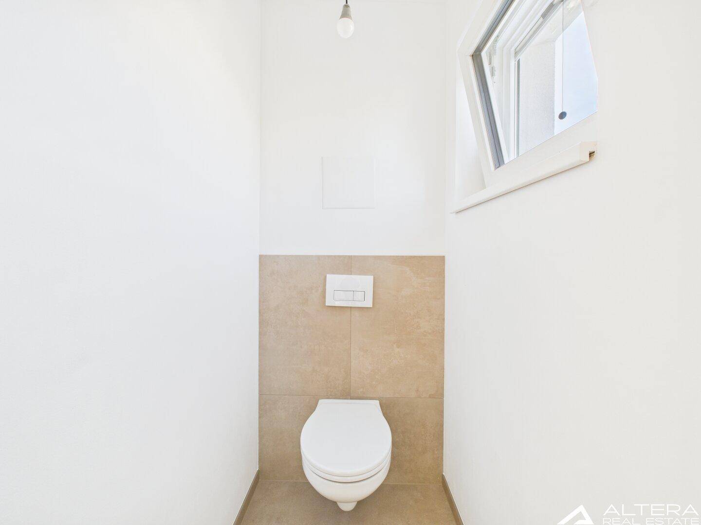 Modernes Gäste-WC mit wandhängender Toilette, Fliesenakzenten und kleinem Fenster.