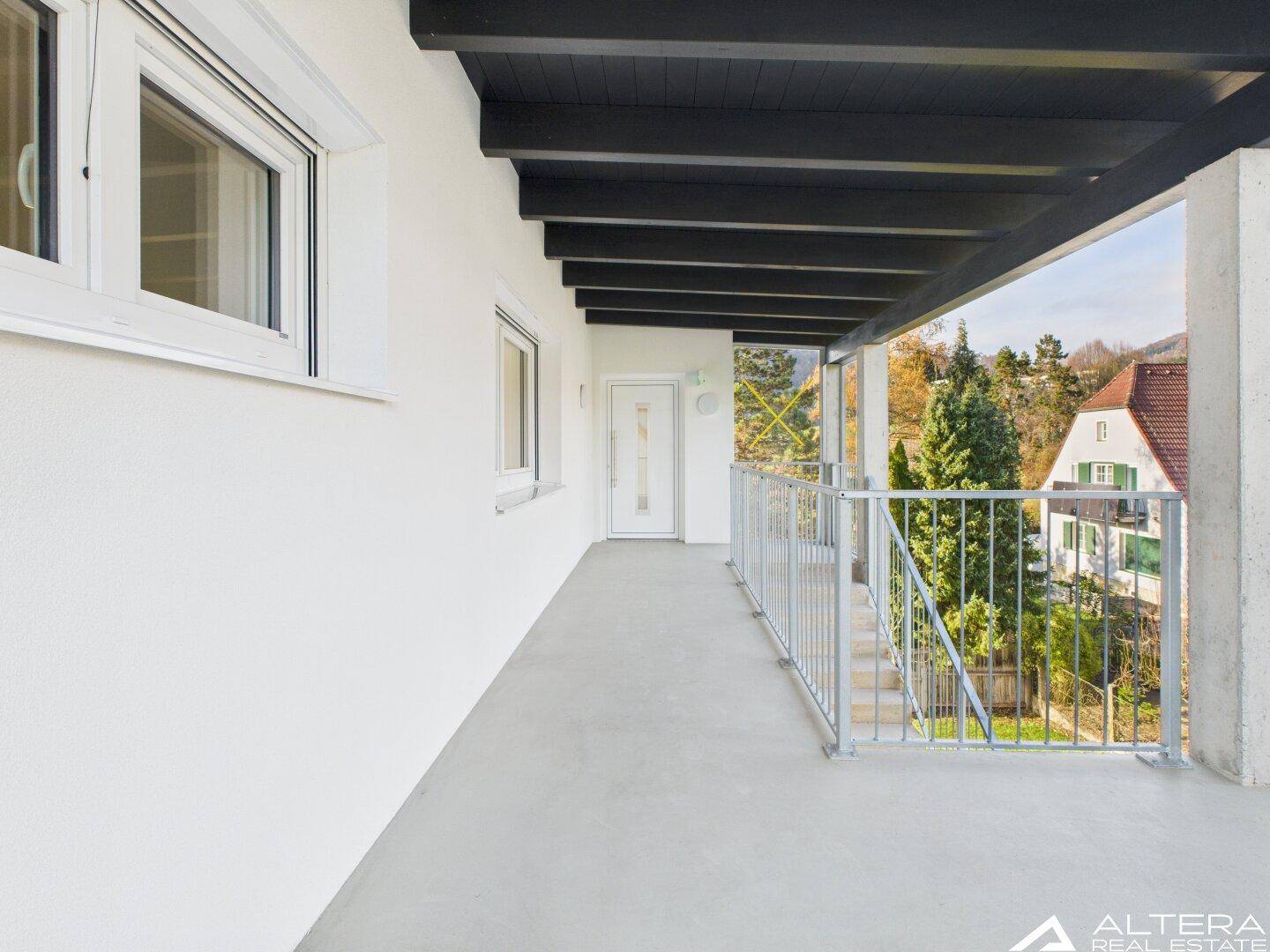 Überdachter Balkon mit weitem Blick ins Grüne, ideal für entspannte Stunden im Freien.