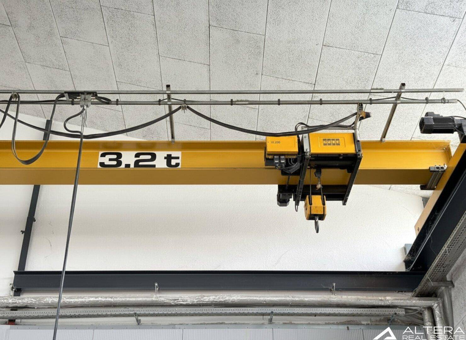 Nahaufnahme eines gelben 3,2 Tonnen Krans, der in der Industriehalle installiert ist und schwere Lasten heben kann.