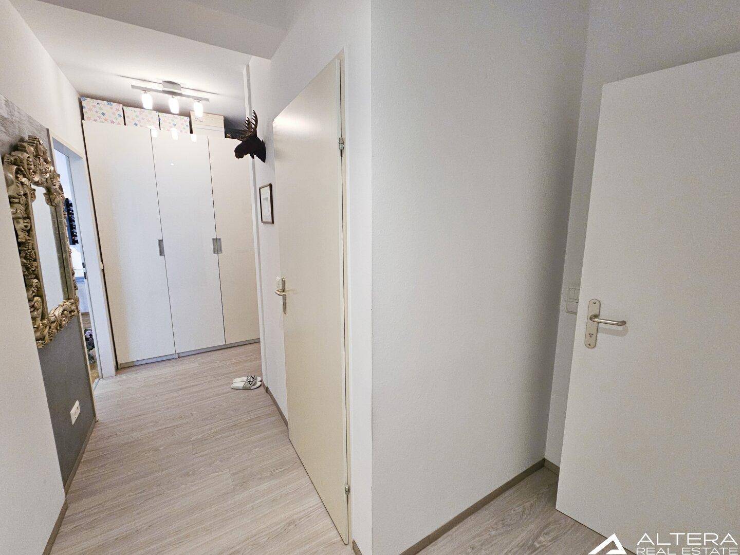 Heller Flur mit modernem Laminatboden und praktischen Einbauschränken.