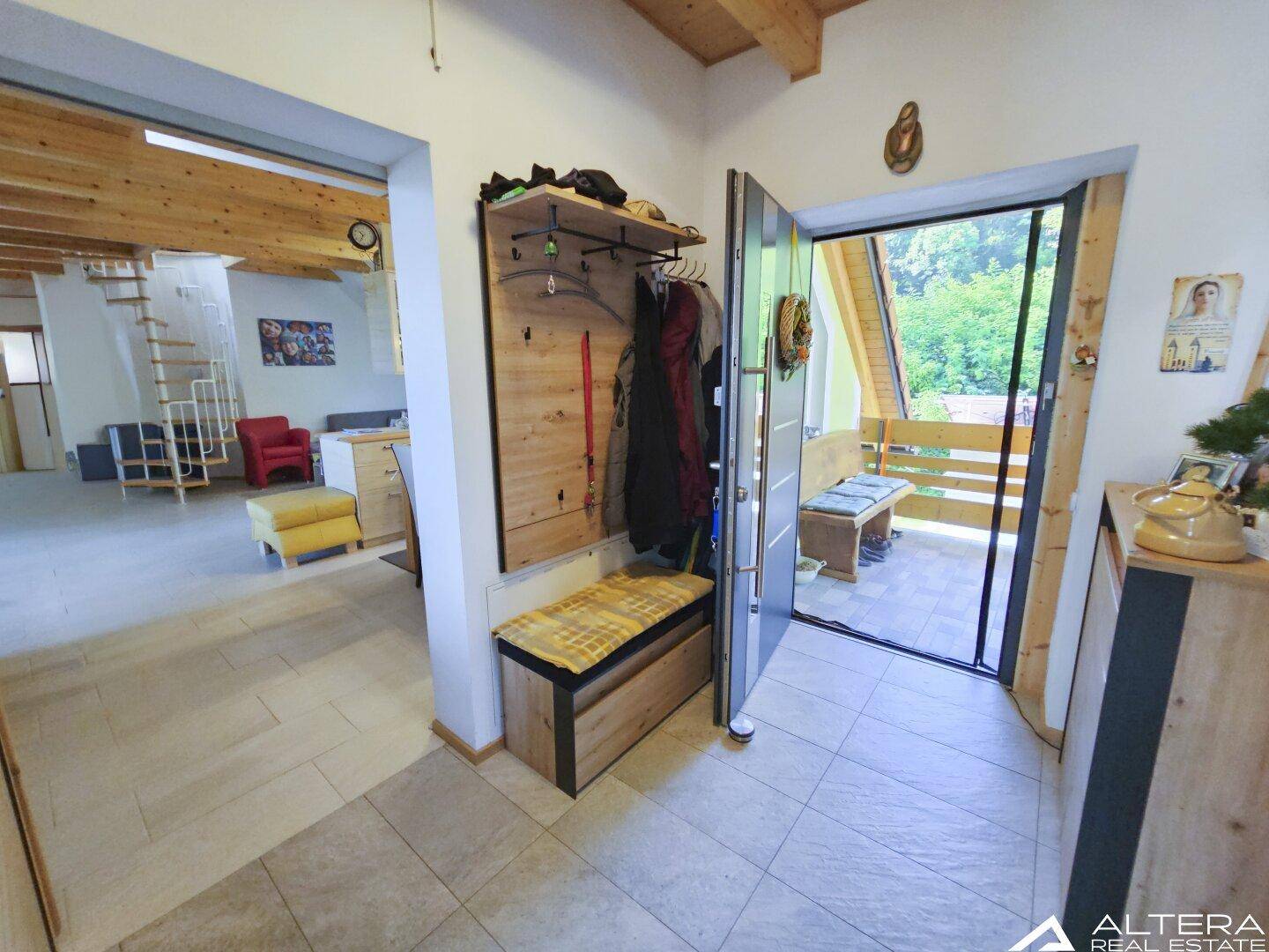 Eingangsbereich mit Garderobe, Fliesenboden und Zugang zu den Wohnbereichen.