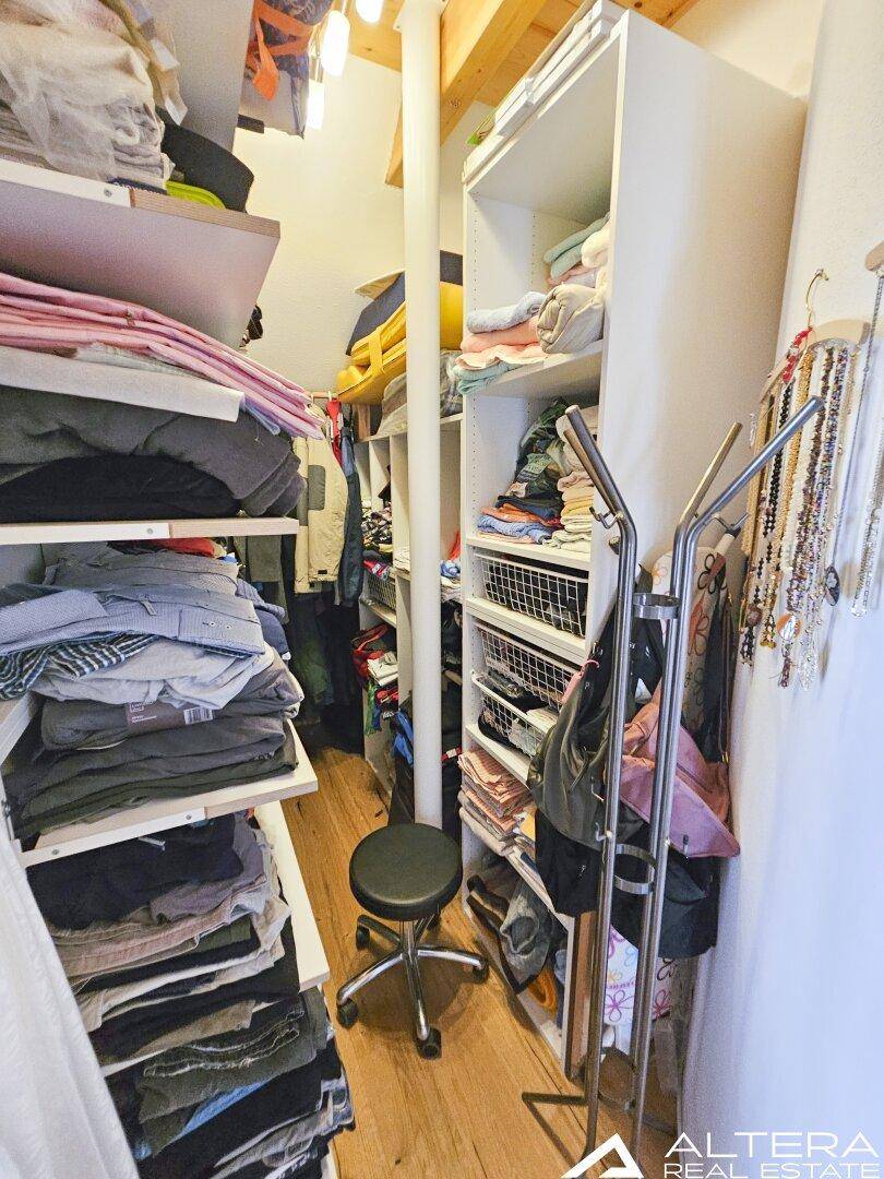 Begehbarer Kleiderschrank mit zahlreichen Regalen und Aufbewahrungsmöglichkeiten für Kleidung.