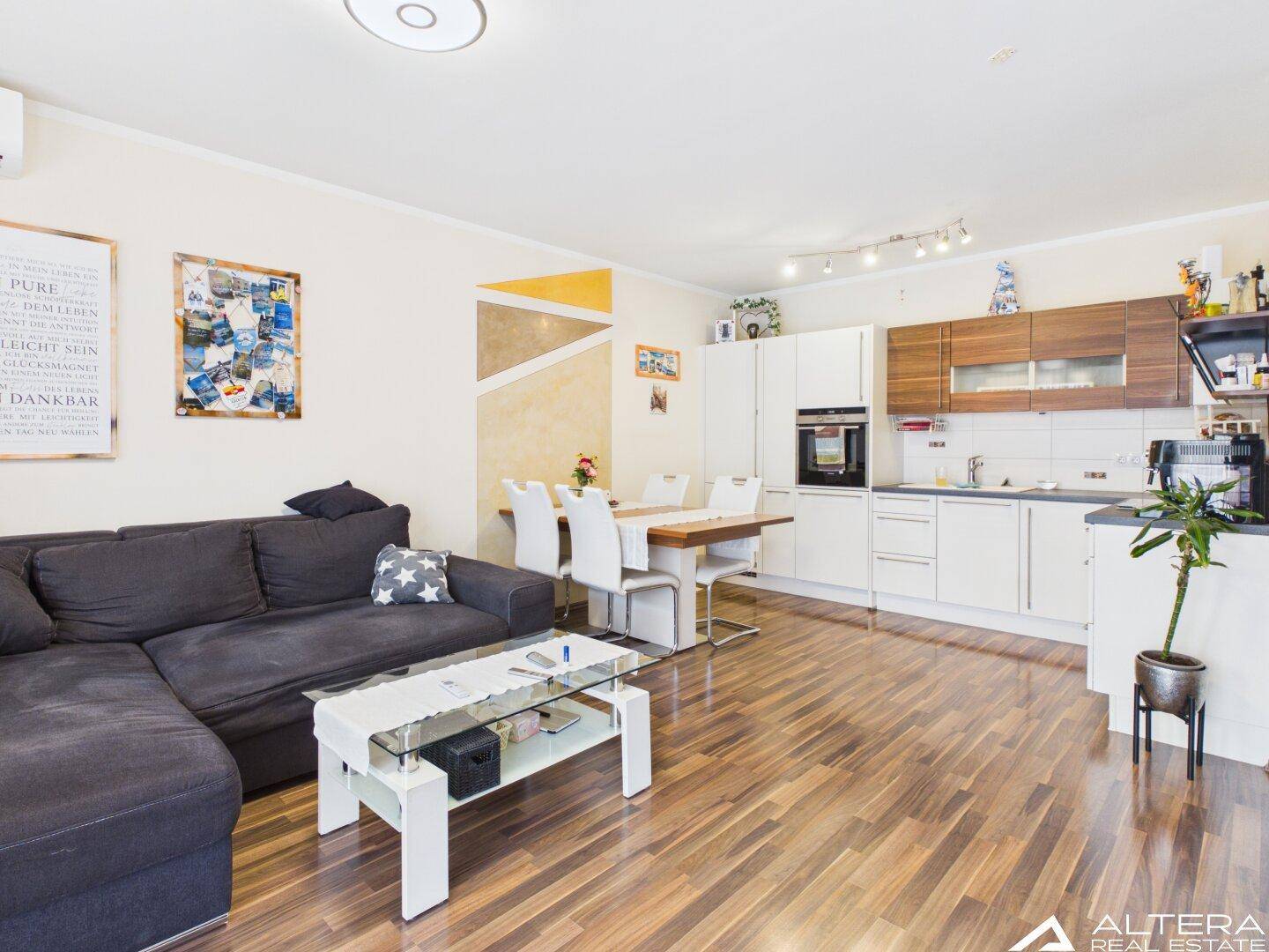 Offener Wohn-Essbereich mit integrierter Küche, Holzfußboden und modernem Design, hell und geräumig.