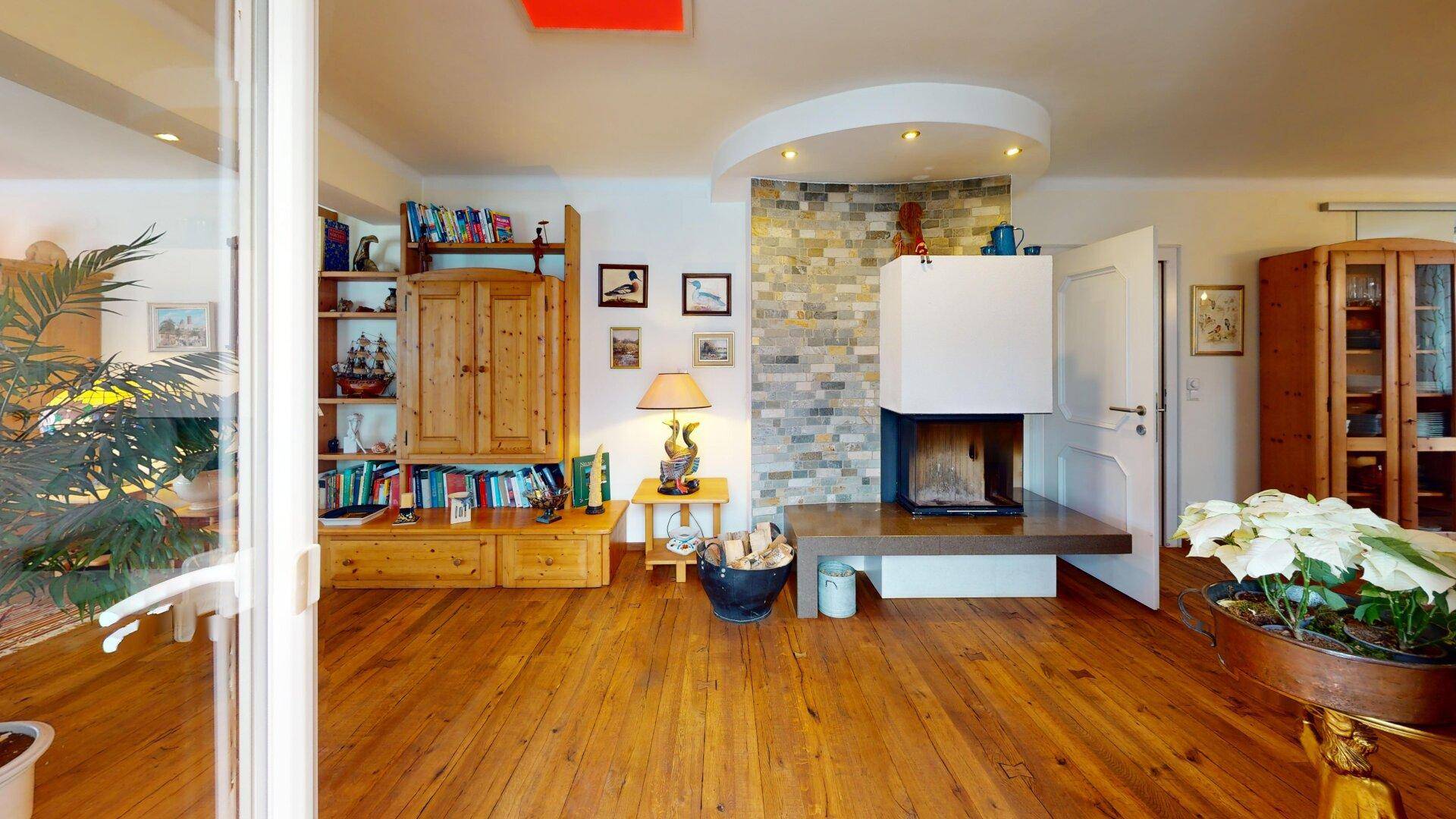 Wohnzimmer mit modernem Kamin, Holzdielenboden und gemütlicher Atmosphäre.