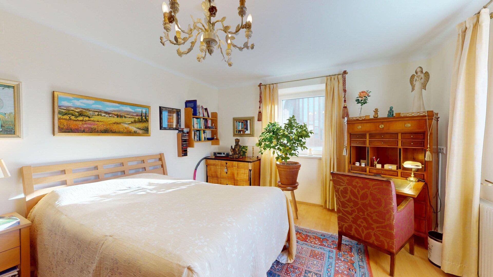 Geräumiges Schlafzimmer mit Doppelbett, Schreibtisch und traditioneller Einrichtung.