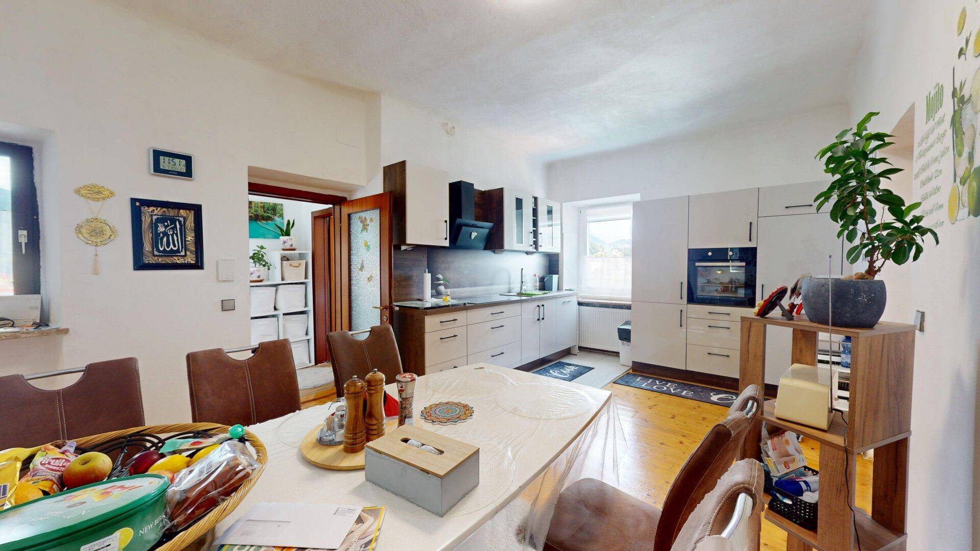 Geräumiger Essbereich mit großem Tisch und Blick auf die moderne Küche, ideal für Familien.