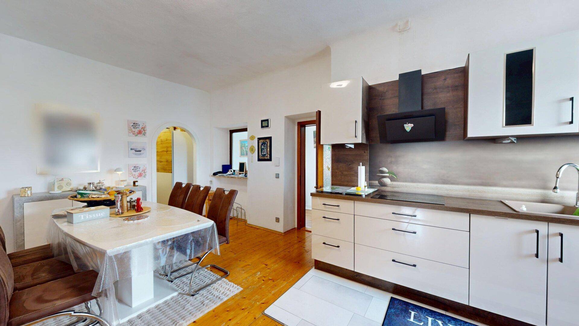 Offener Wohn-Essbereich mit Esstisch und moderner Küche, ideal für geselliges Beisammensein.