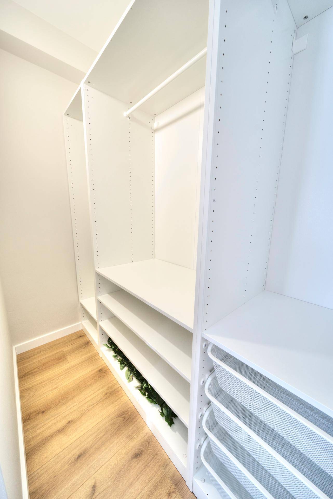 Geräumiger begehbarer Kleiderschrank mit Regalen und Schubladen.