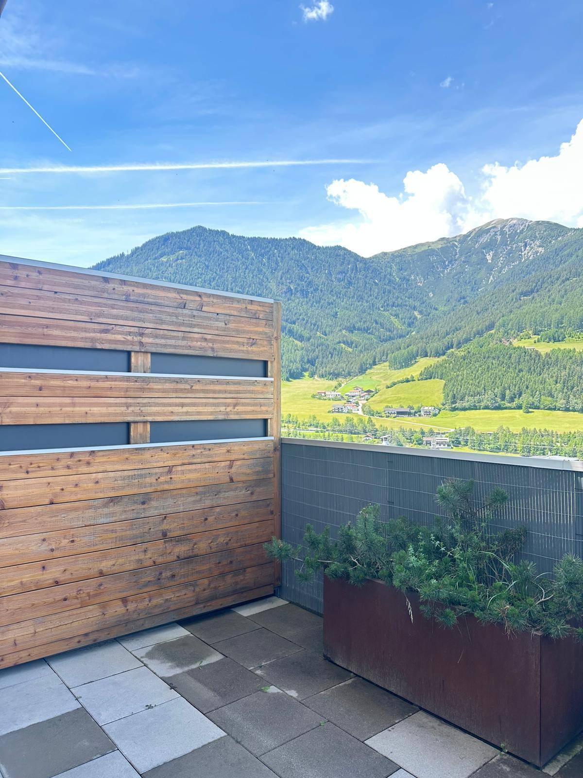 Geräumige Terrasse mit Bergblick und Holzelementen, ideal zum Entspannen im Freien.