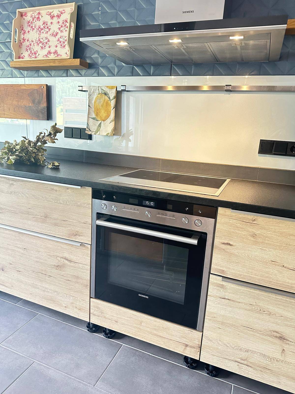 Detailansicht des Backofens und Induktionskochfeldes in der modernen Küche mit Holzfronten.