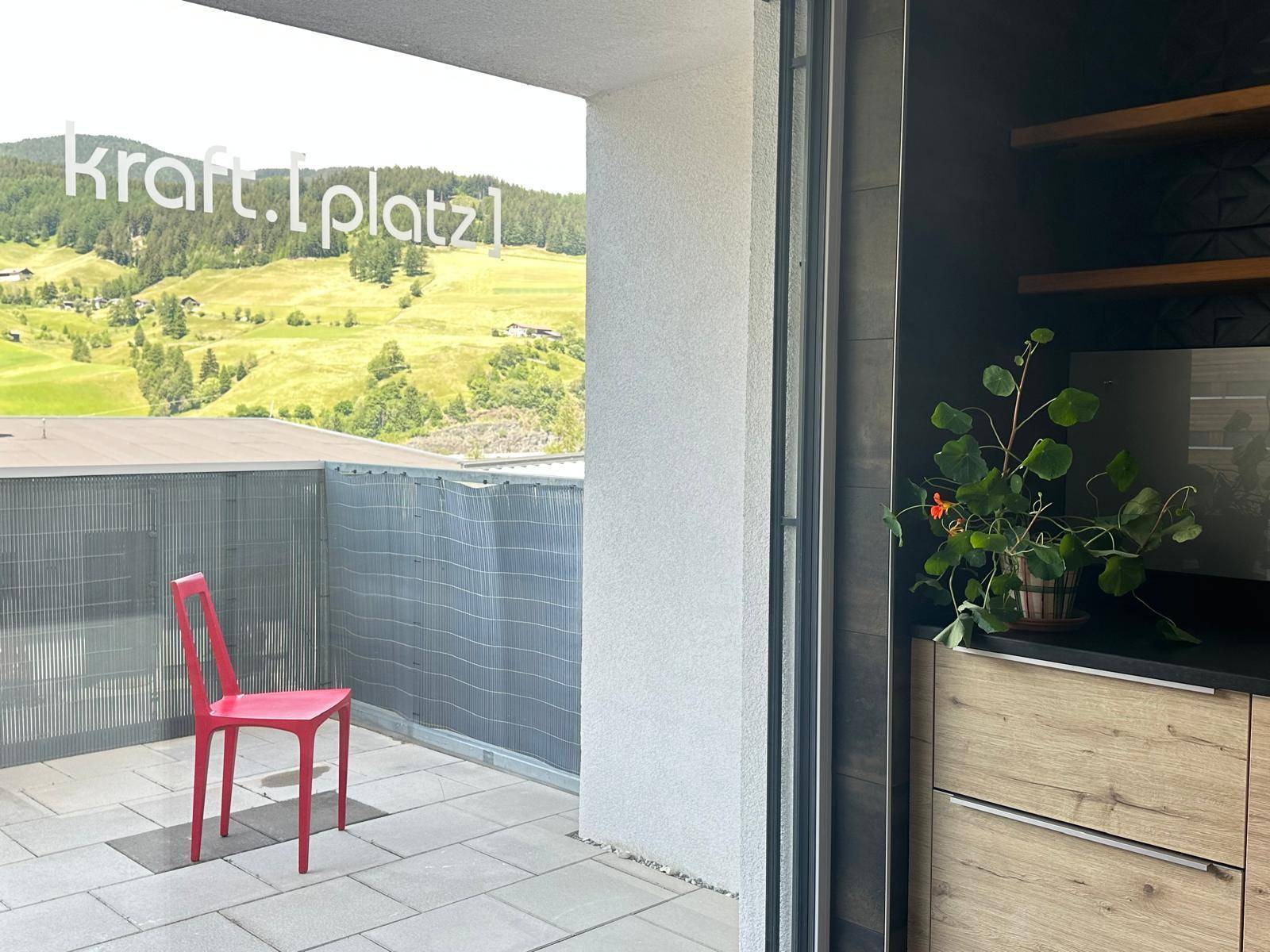 Balkon mit Bergblick und einer roten Sitzgelegenheit, bietet einen schönen Ausblick auf die Landschaft.