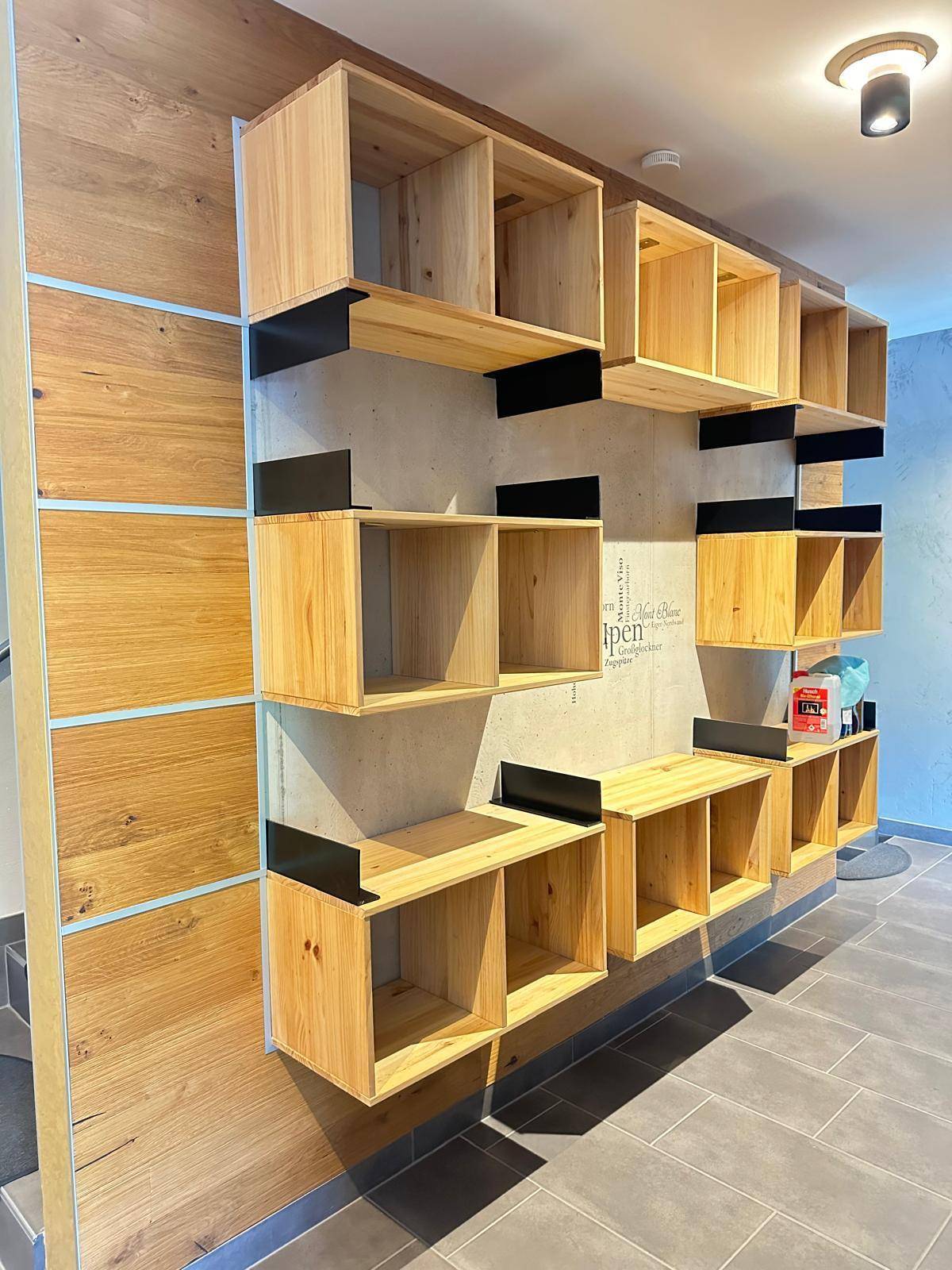 Individuelles Wandregalsystem aus Holz und Metall, bietet praktischen Stauraum und dekorative Akzente.