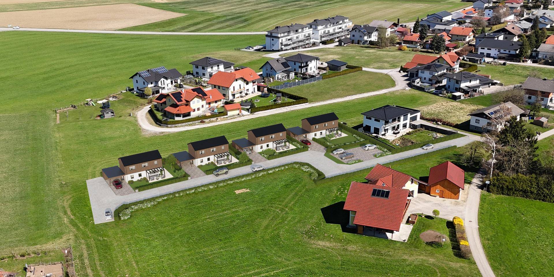 Luftaufnahme einer neuen Wohnsiedlung mit modernen Häusern, umgeben von grünen Feldern.