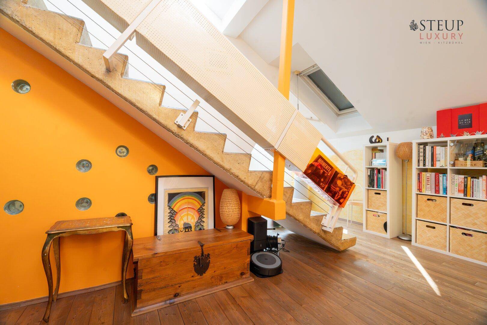 Detailansicht des modernen Treppenaufgangs mit orangefarbener Wand und Holzboden.