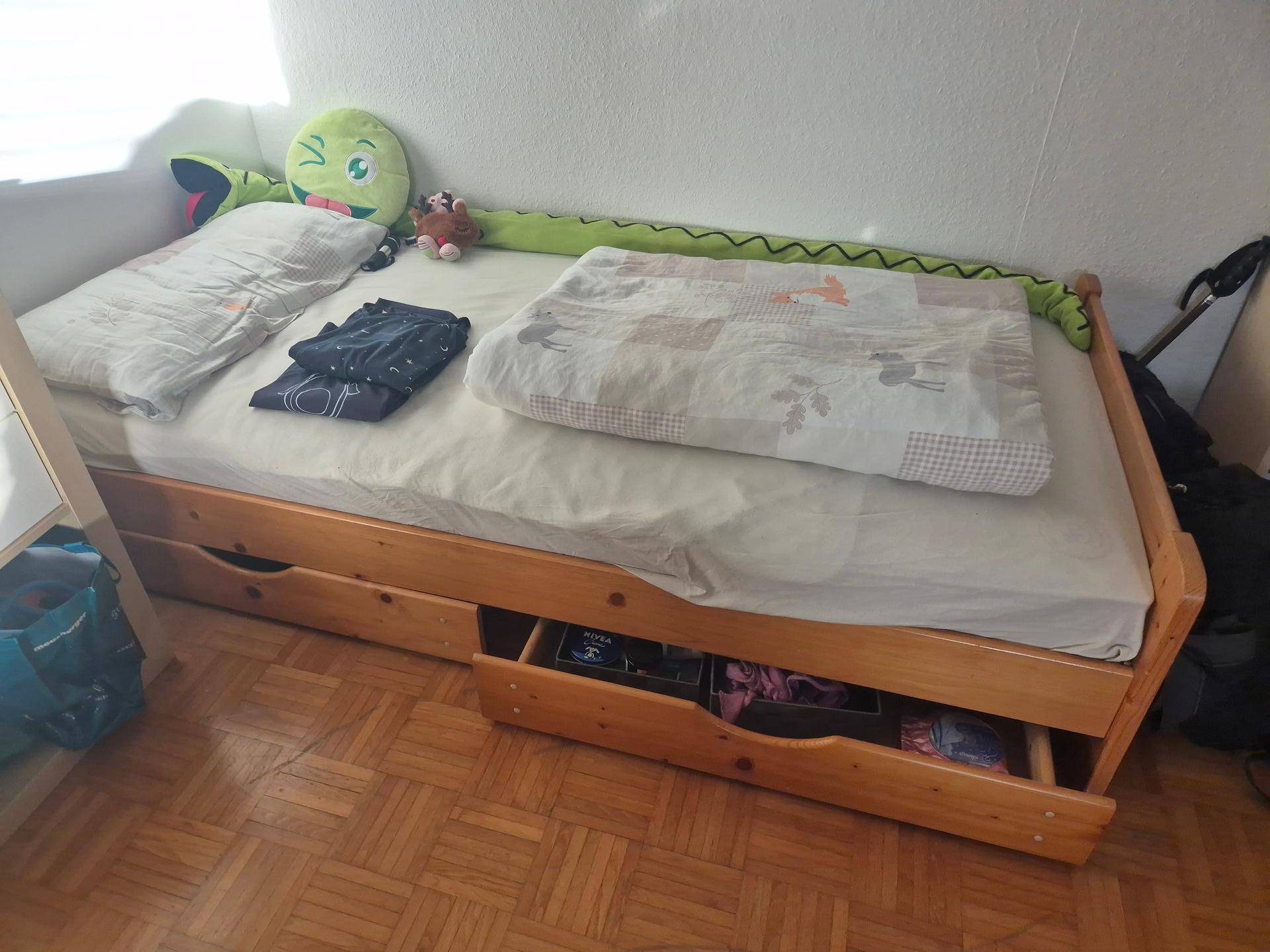Holzbett mit praktischen Auszugsschubladen für zusätzlichen Stauraum.
