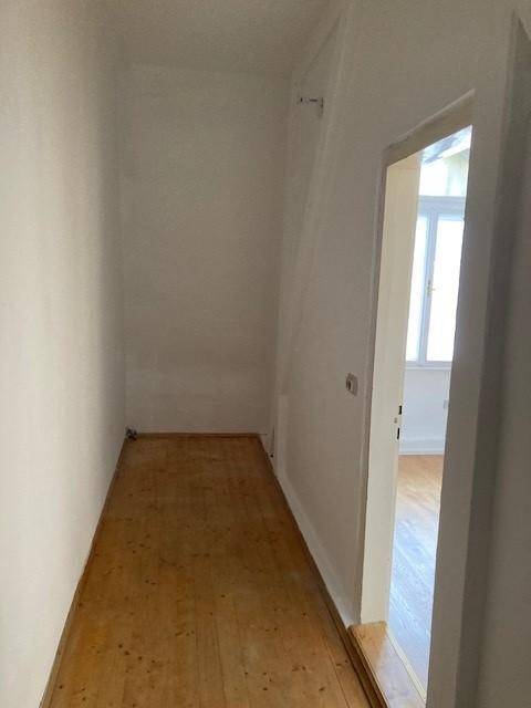 Praktischer Abstellraum mit Holzdielenboden und weißen Wänden, ideal für zusätzlichen Stauraum.