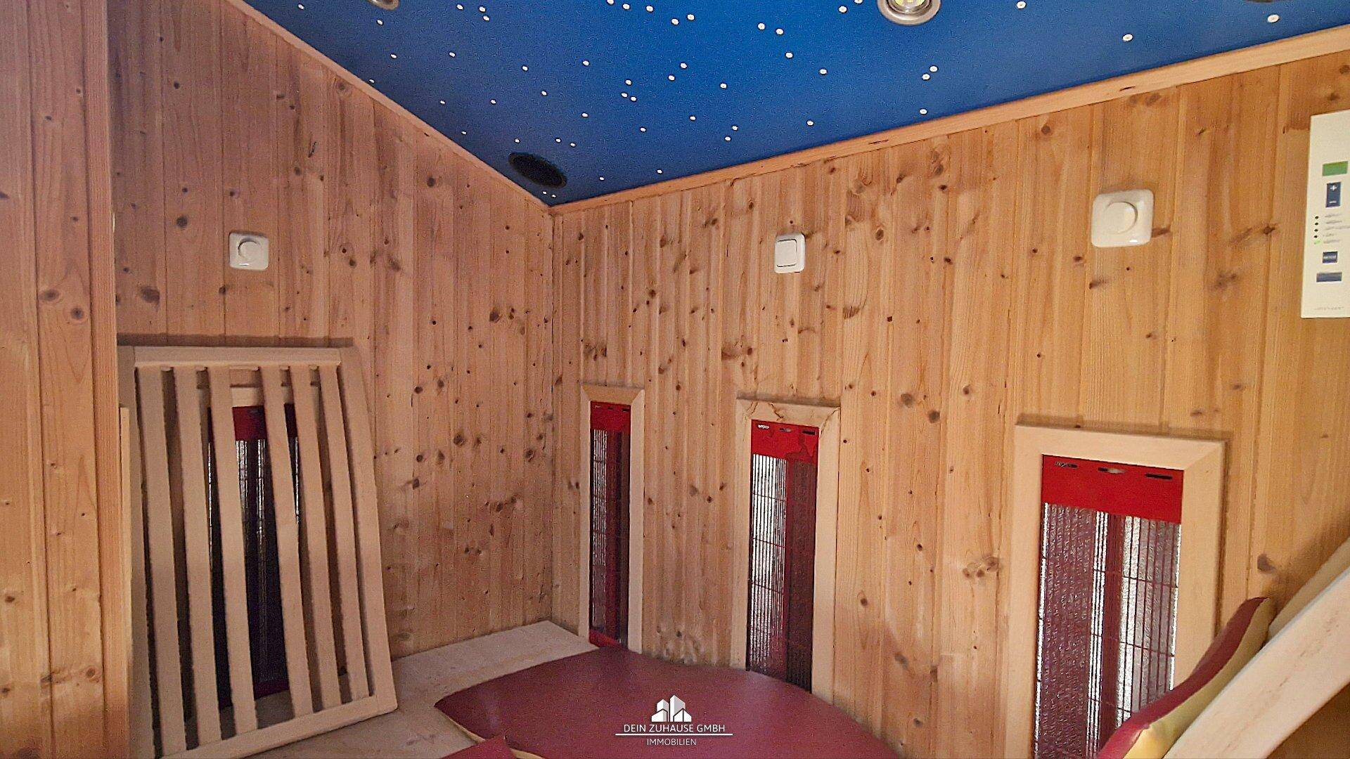 Wellnessbereich mit Holzvertäfelung, Infrarotkabinen und Sternenhimmel-Decke.