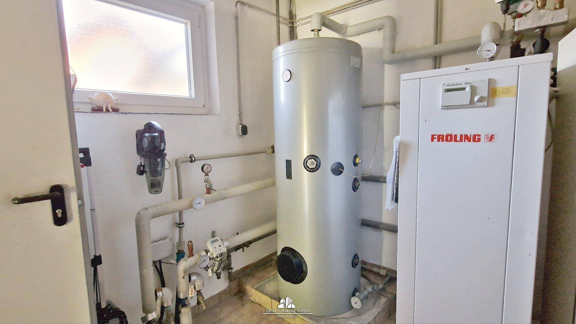 Heizungsraum mit großem Warmwasserspeicher und moderner Froling-Heizanlage.