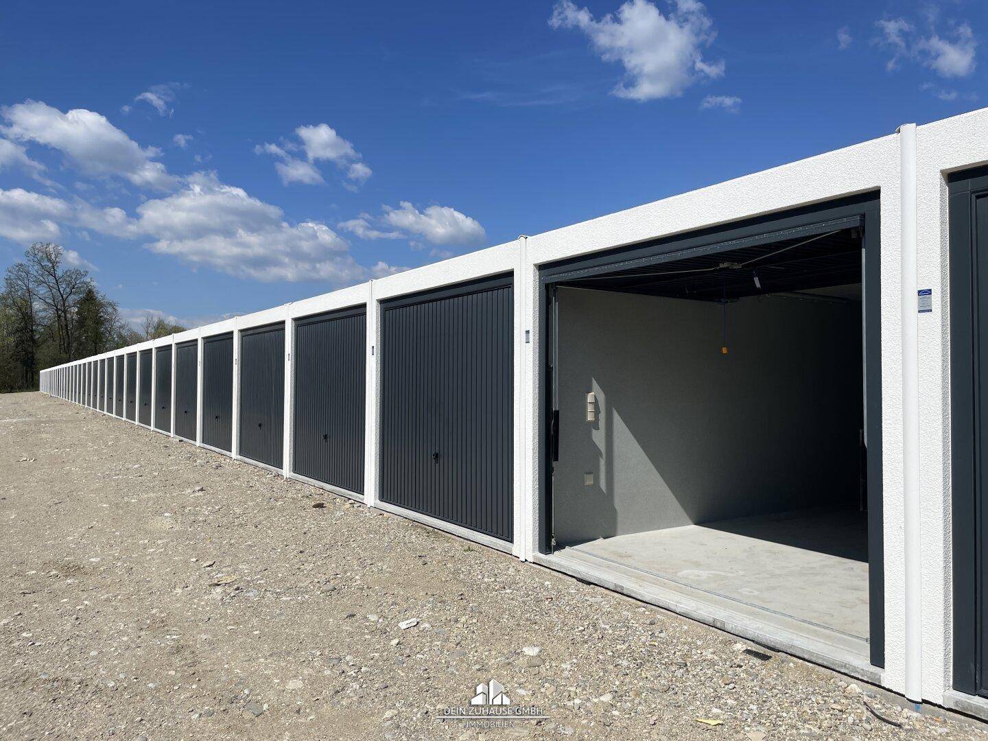Lange Reihe von Garagenboxen mit offenen und geschlossenen Toren.