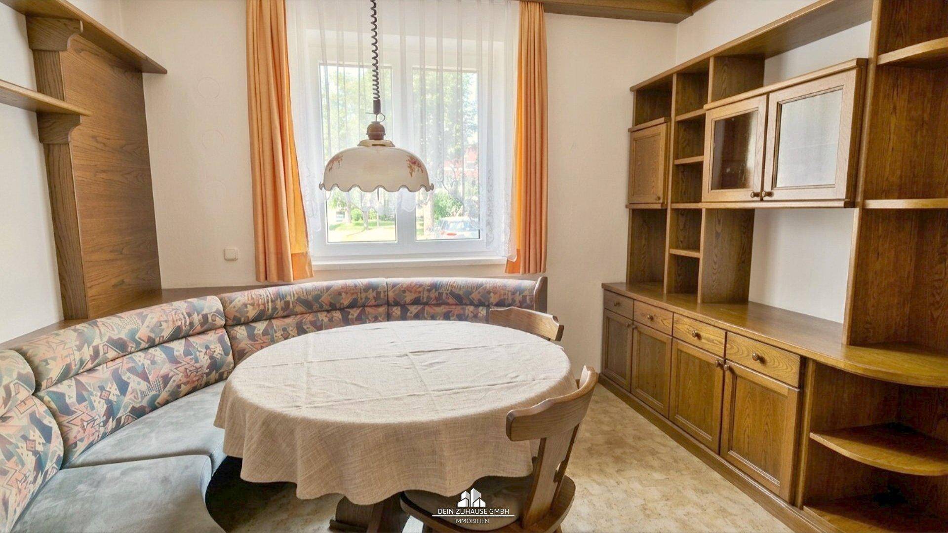 Gemütlicher Essbereich mit Eckbank, Holztisch und passenden Regalen.
