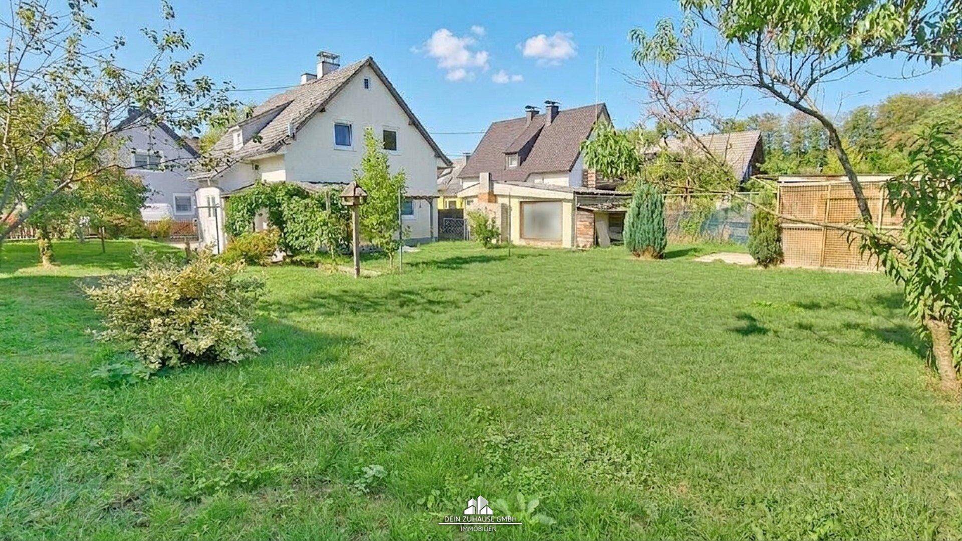 Großer, gepflegter Garten mit weitläufiger Rasenfläche und Bäumen, ideal für Erholung im Freien.
