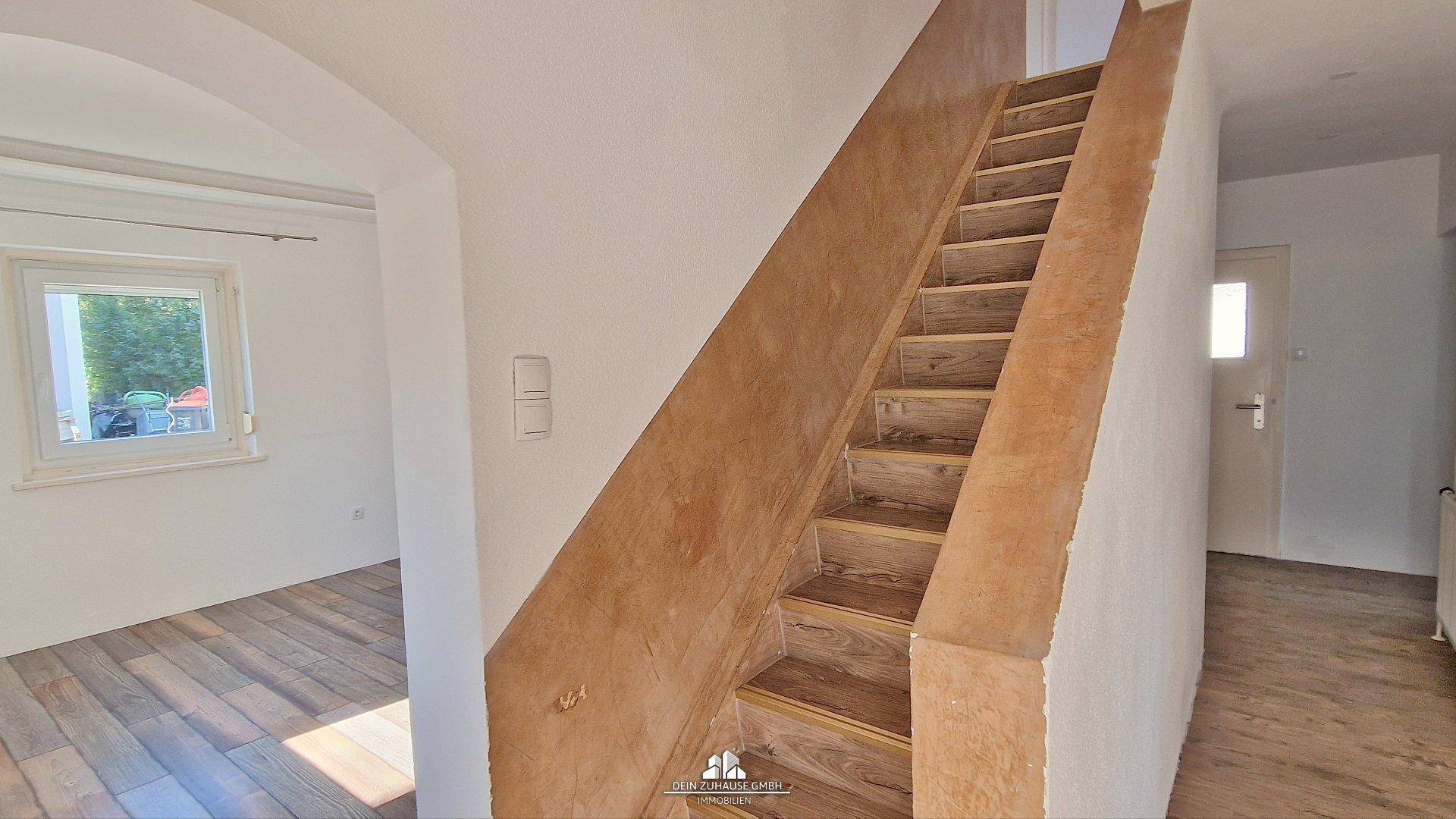 Holztreppe mit modernem Design, die die verschiedenen Etagen des Hauses miteinander verbindet.