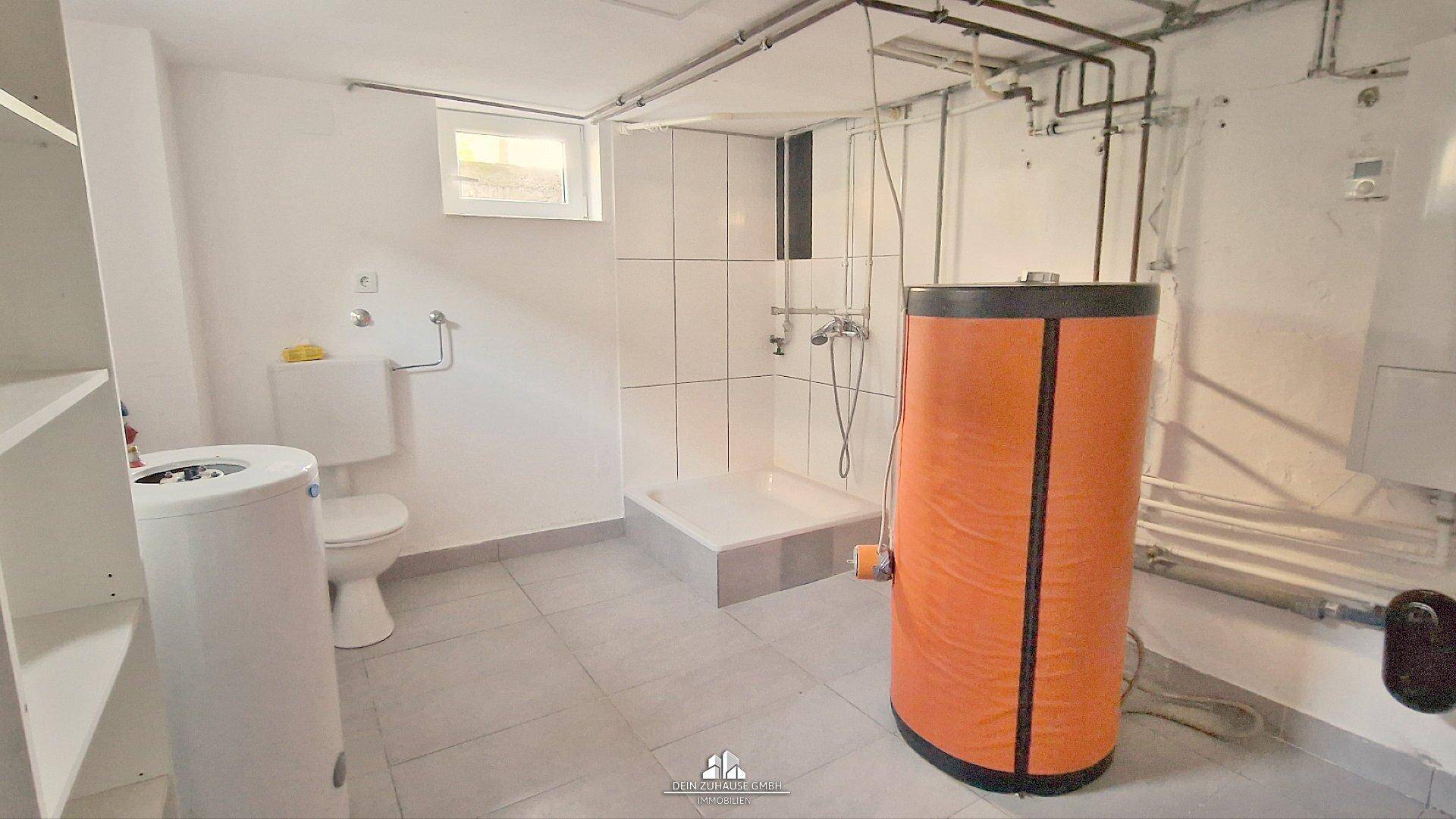 Kellerraum mit Dusche, Toilette und Warmwasserspeicher, ideal als Waschküche oder Hobbyraum.