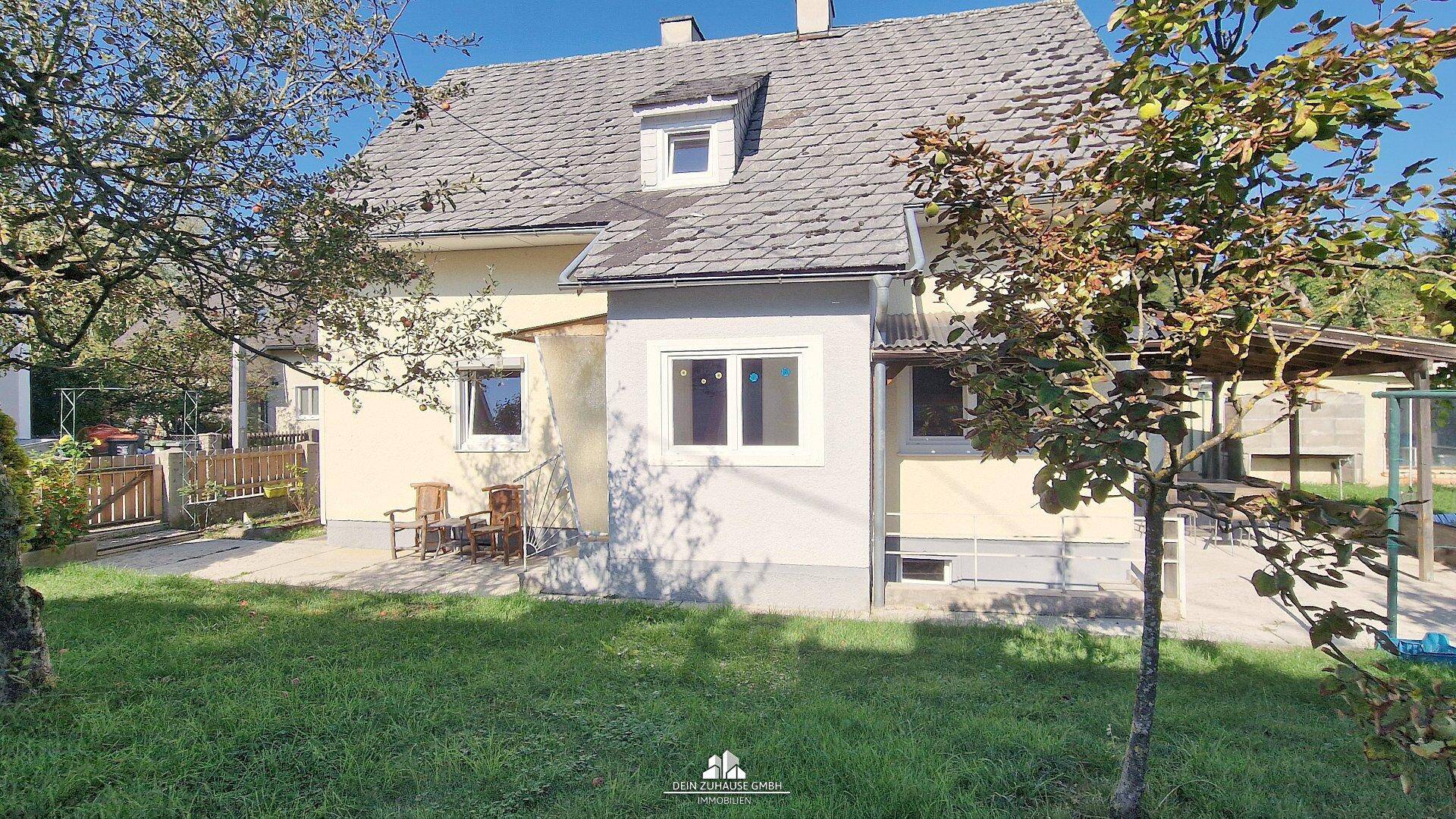 Seitenansicht des Hauses mit Gartenbereich, Terrasse und Blick auf die umliegende Natur.