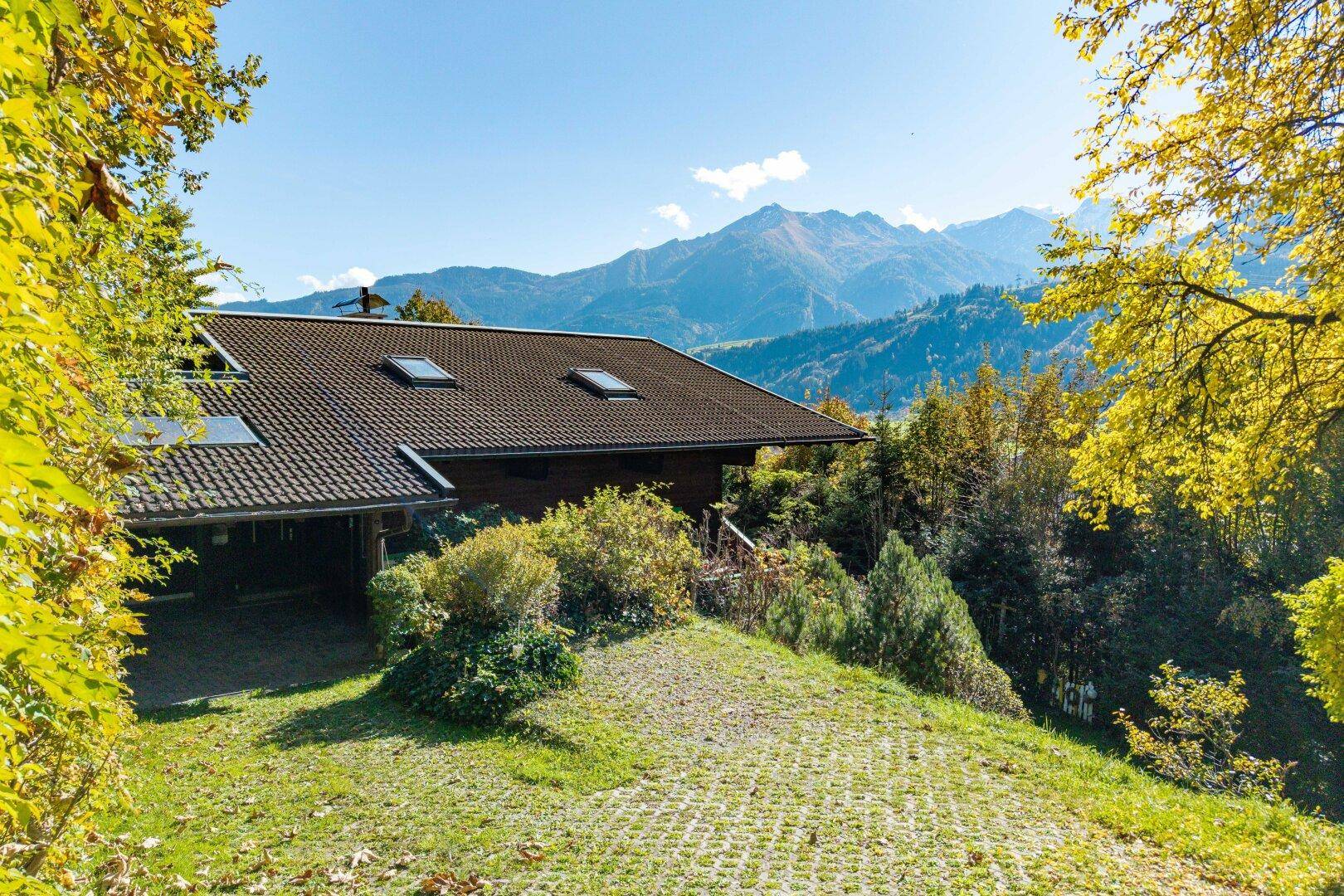 Charmantes Holzhaus in alpiner Umgebung mit Bergblick und grüner Landschaft.