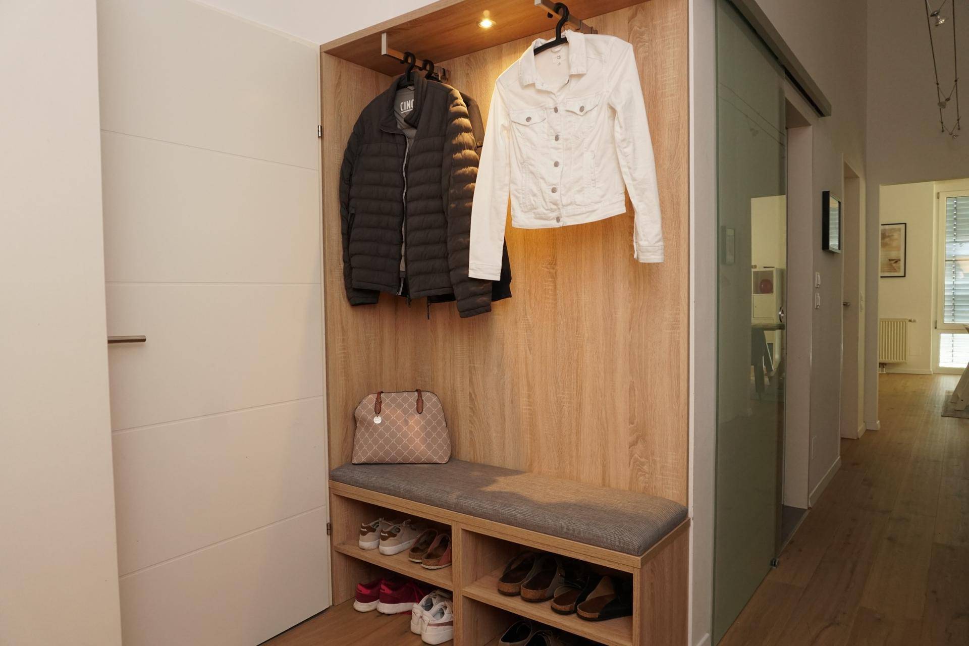 Praktischer Flur mit Garderobe, Sitzbank und Schuhablage, ideal für den Eingangsbereich.