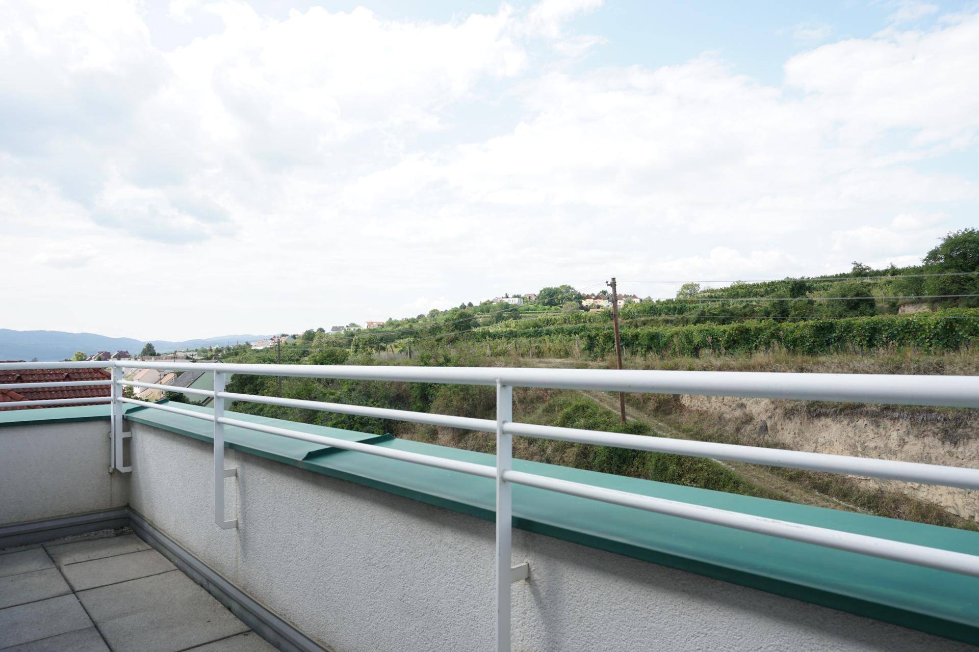 Balkon mit Fliesenboden und weitem Blick auf die umliegenden Weinberge und Hügel.