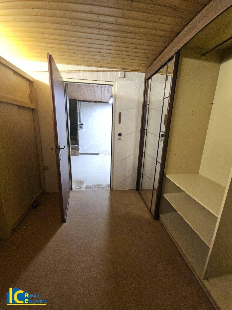 Kellerraum mit Teppichboden, Einbauschränken und Zugang zu weiteren Räumen.