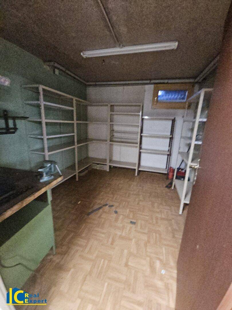 Werkstatt im Keller mit Regalen, Werkbank und Fenster für handwerkliche Tätigkeiten.