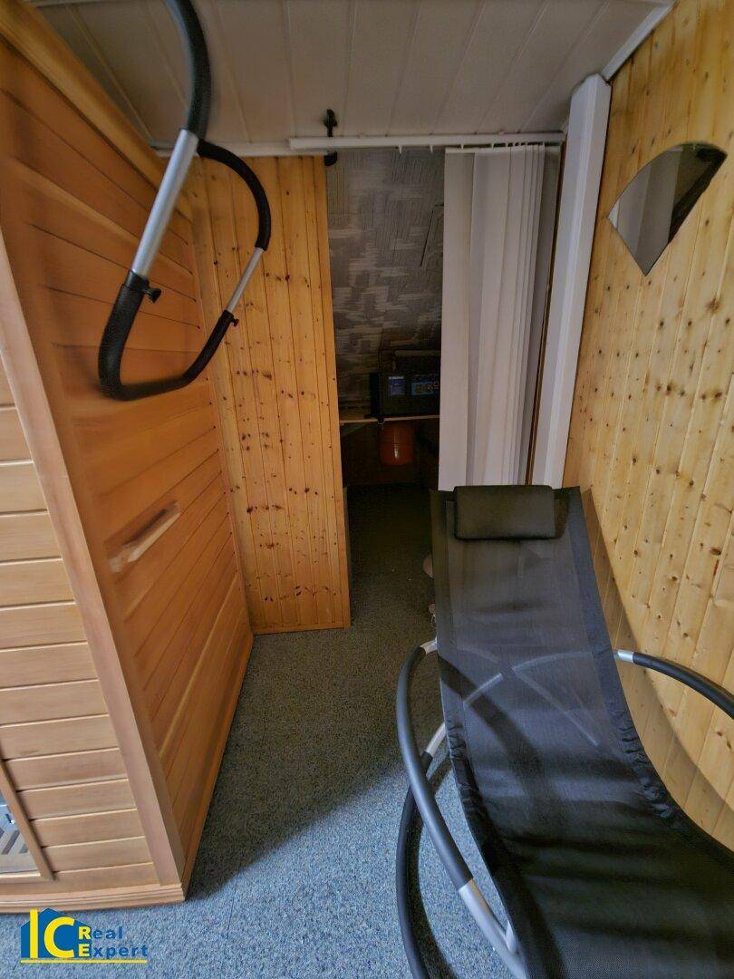 Gemütlicher Wellnessbereich mit Sauna und Liegestuhl, ideal zur Entspannung nach dem Training.