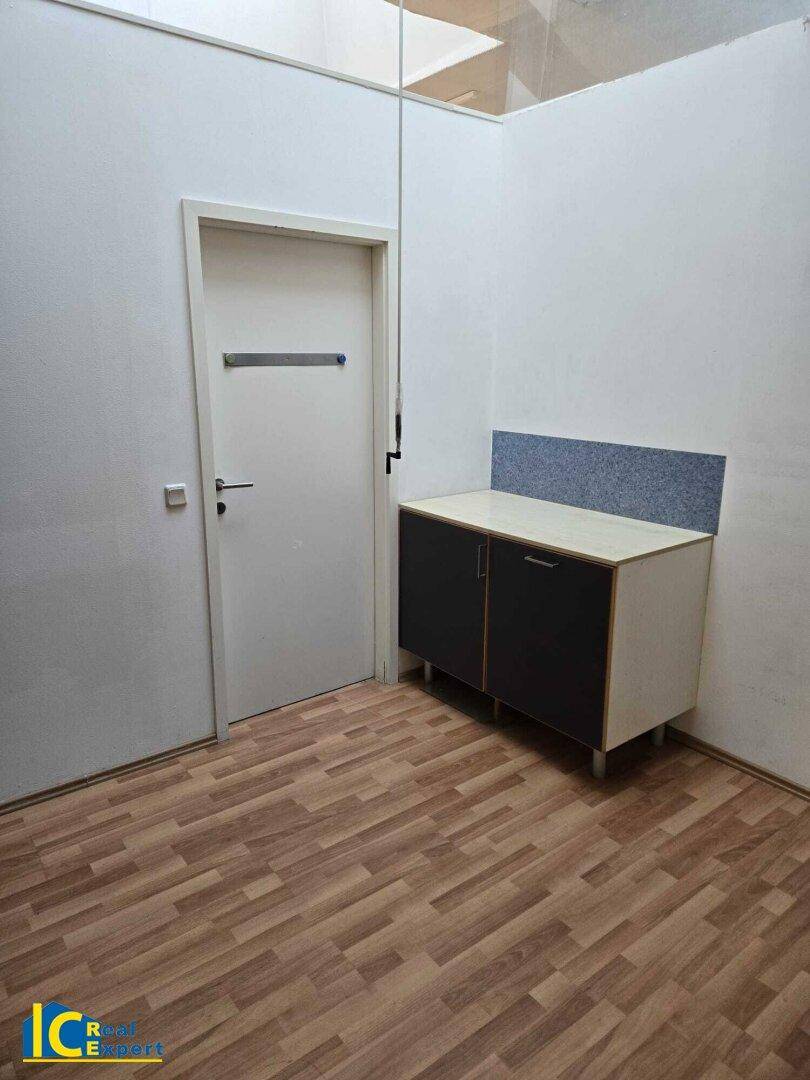Einfaches Zimmer mit Laminatboden und einem kleinen Schrank, geeignet als Büro oder Nebenraum.
