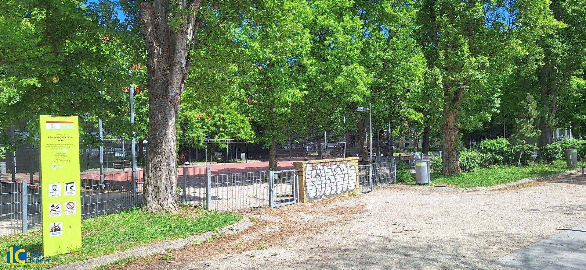 Sportplatz im Freien, umgeben von Bäumen und einem Zaun, ideal für Freizeitaktivitäten.